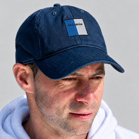 A man wearing a navy blue cotton baseball cap with a small rectangular patch on the front that reads 'AN CHLOE', paired with a white hoodie against a light gray background.