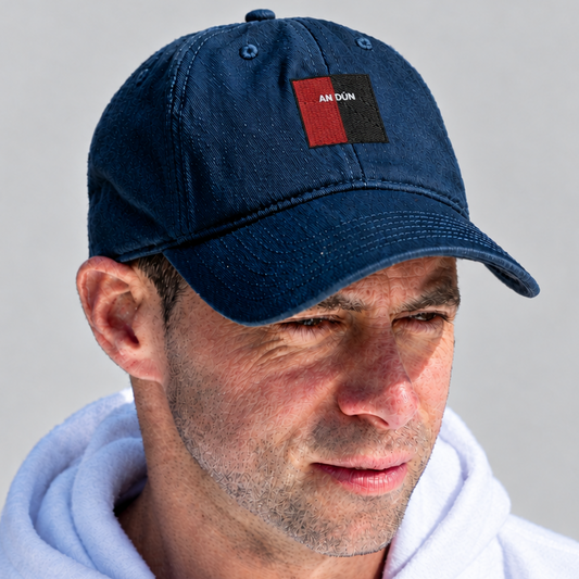 A man wearing a navy blue baseball cap with a red and black square logo patch that reads 'ANTOIKI'. He is also wearing a white hoodie against a plain light gray background.