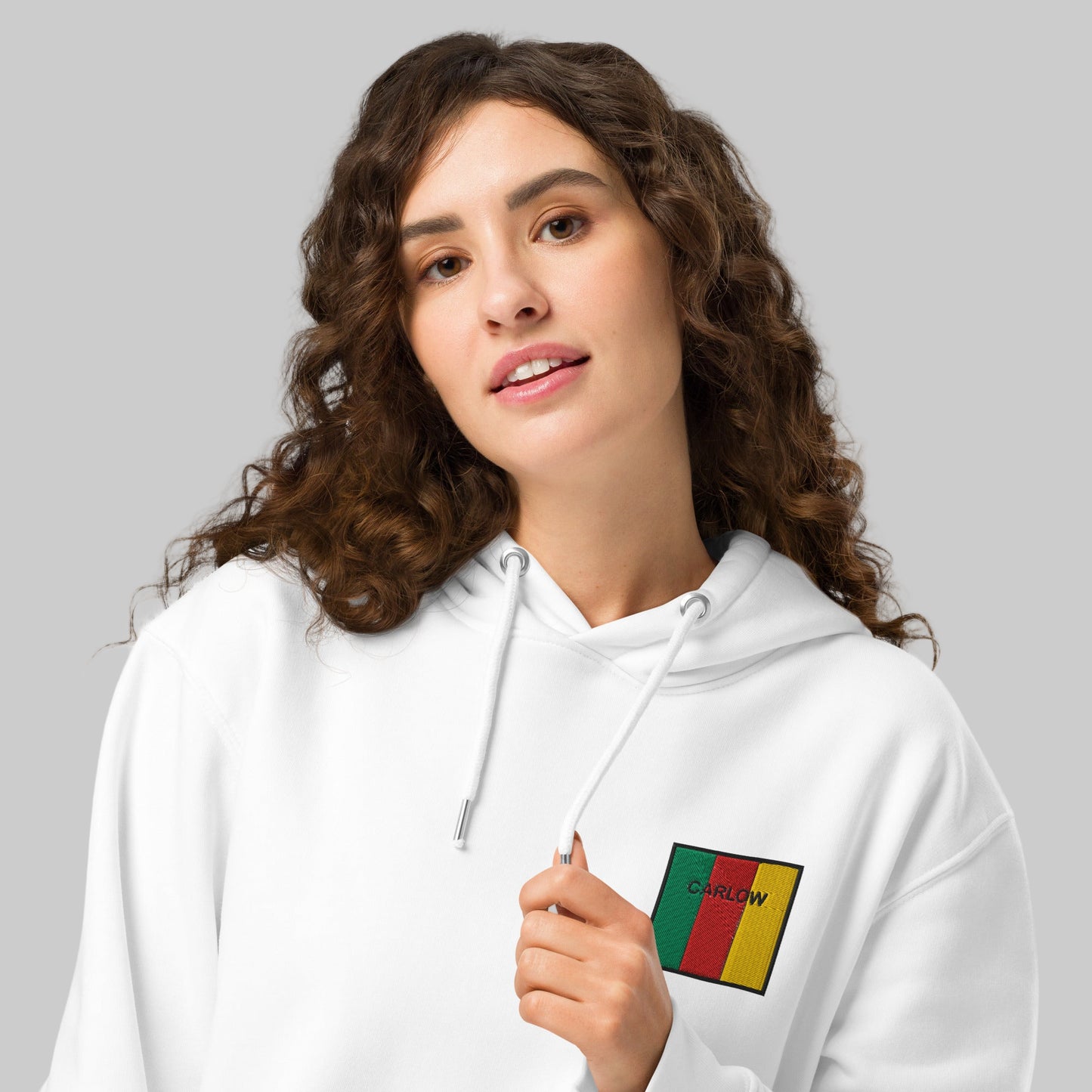 Woman wearing white hoodie with Carlow emblem 
