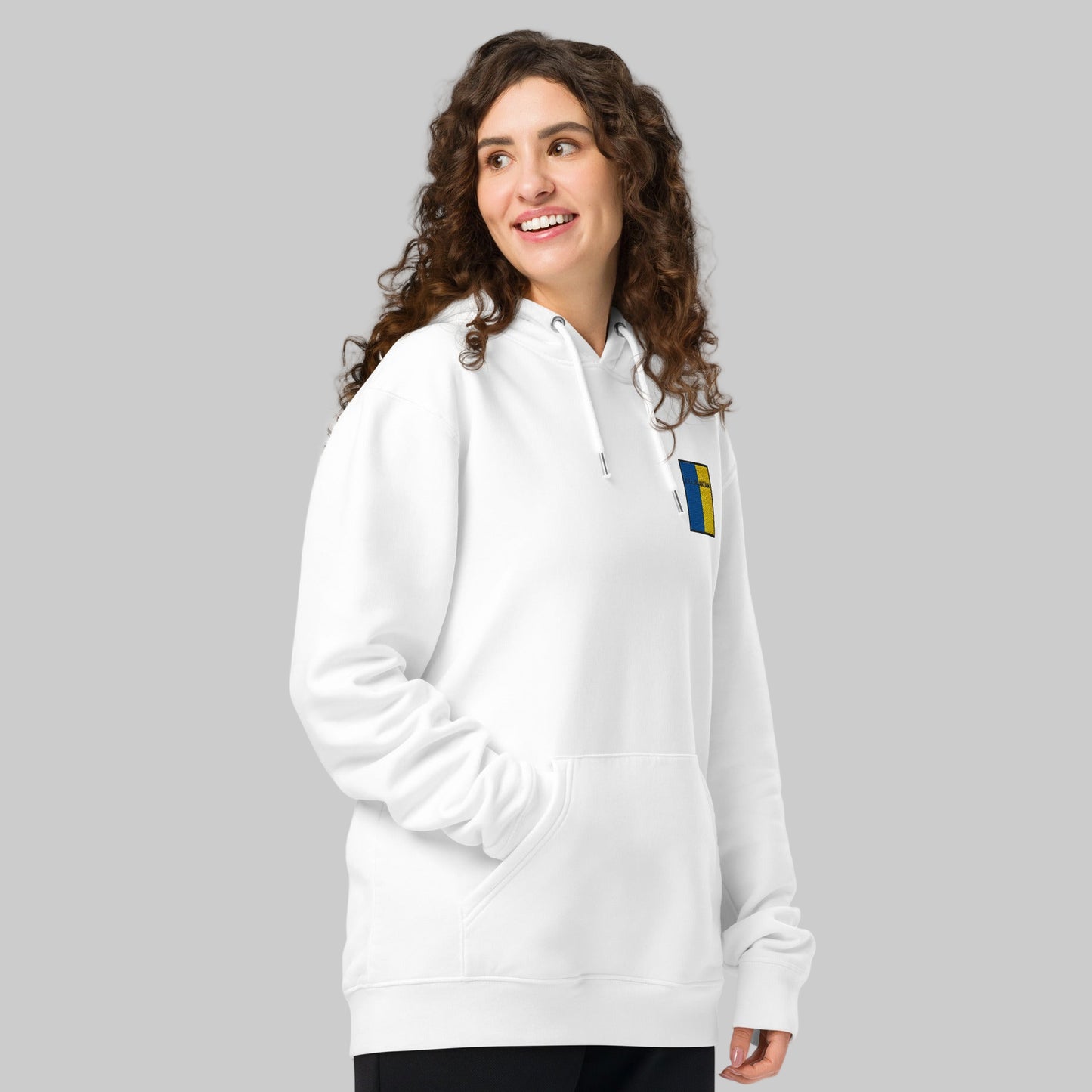 Woman wearing a white hoodie with cill Mhaintáin emblem front left