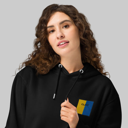 Woman wearing a black hoodie with Clare emblem front left 