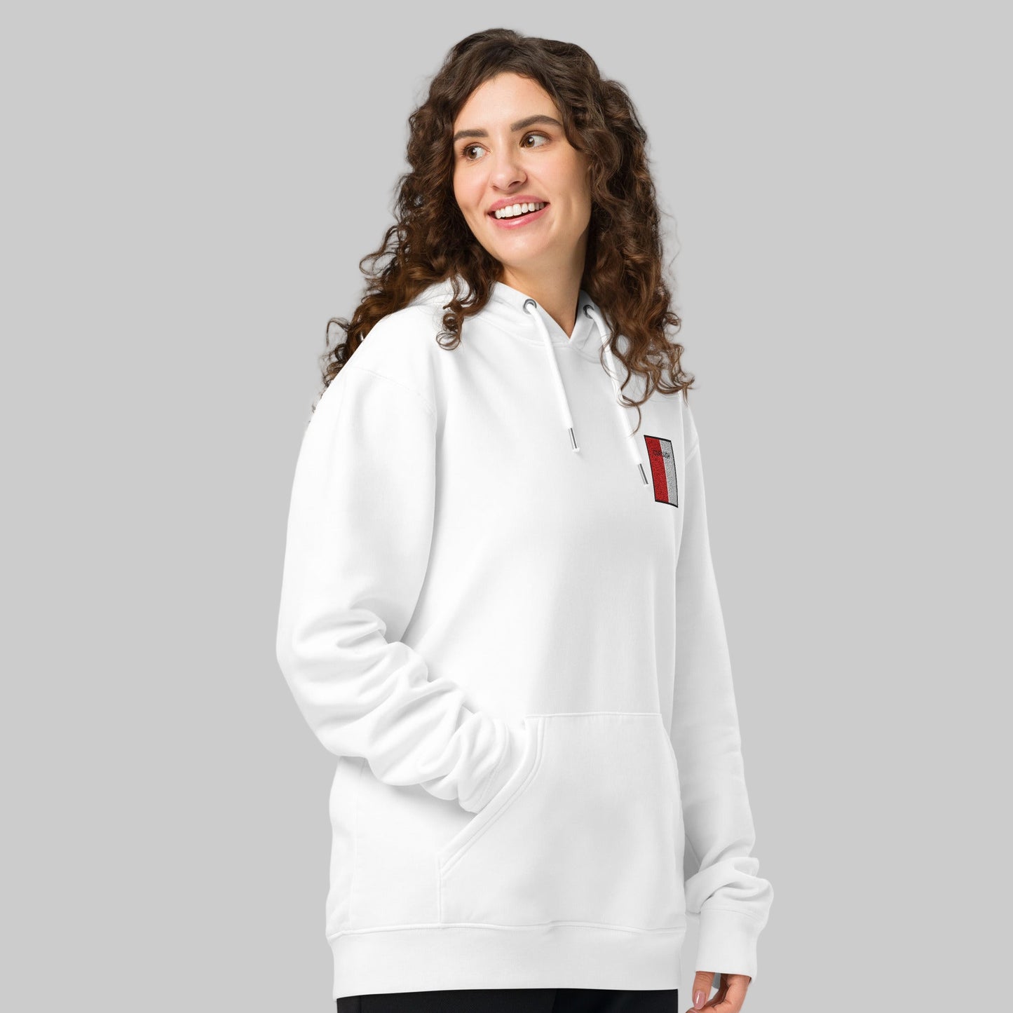 Woman wearing a white hoodie with embroidered Corcaigh emblem 