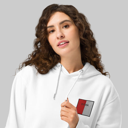 Woman wearing a white hoodie with cork emblem
