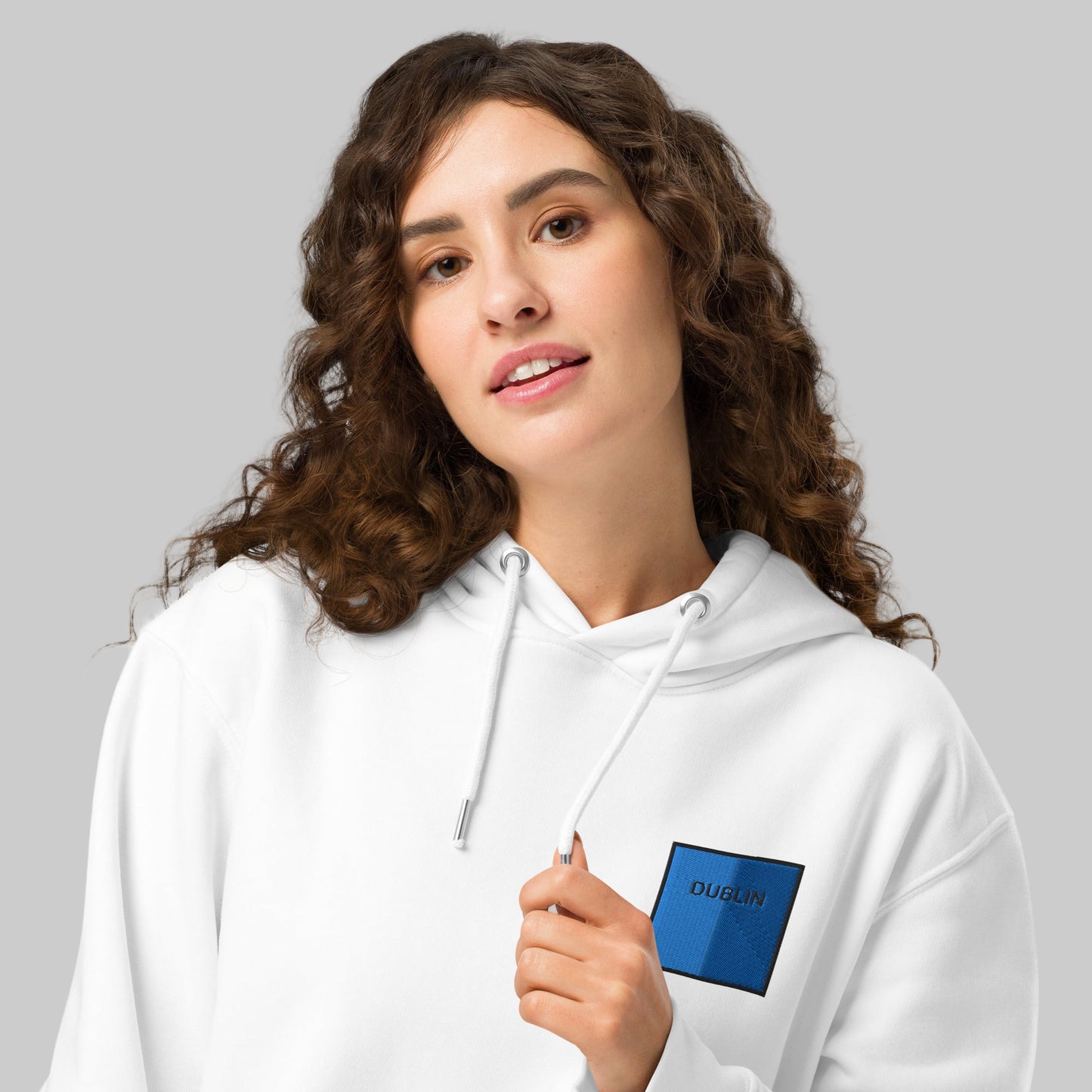 Woman wearing a white hoodie with a Dublin emblem 