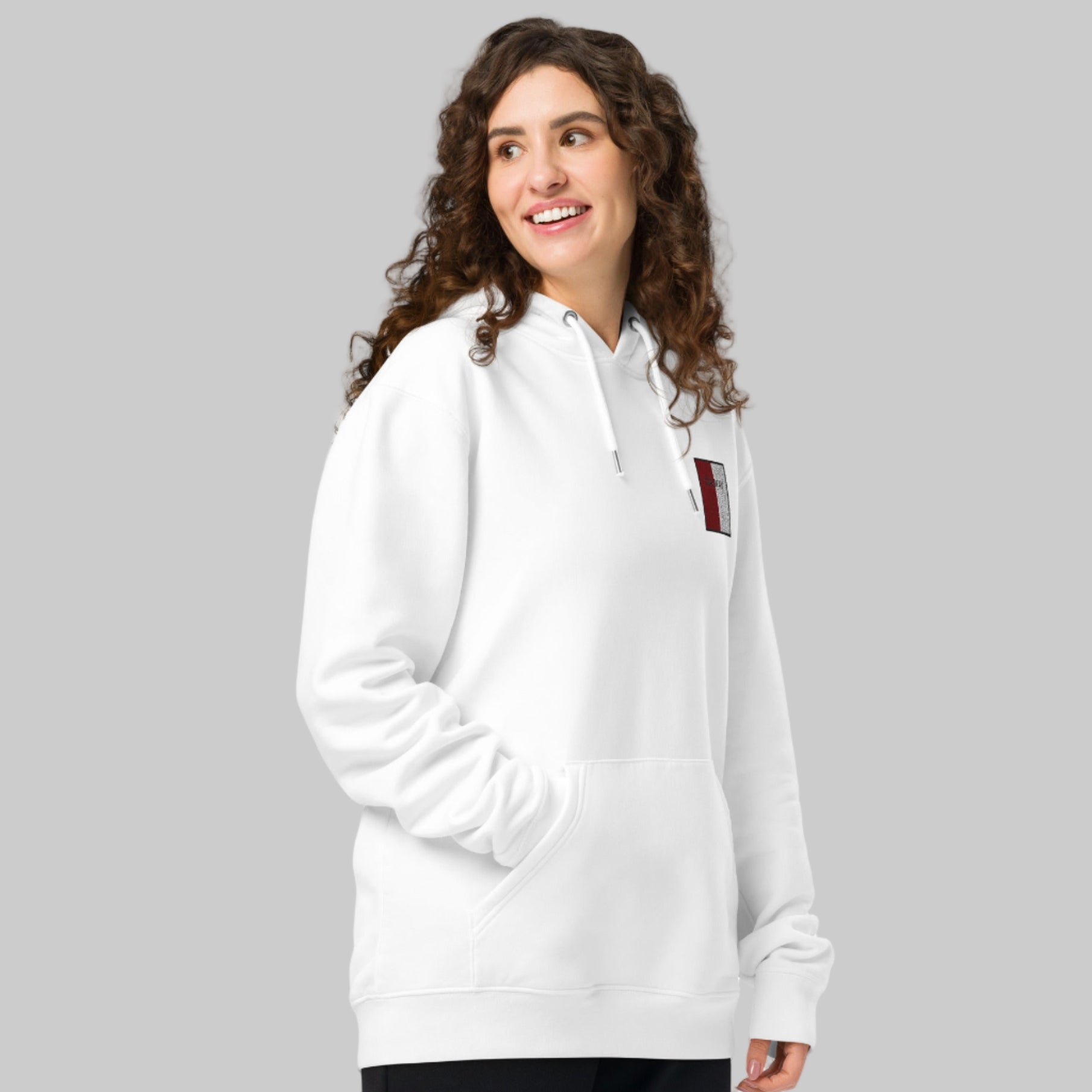 Woman wearing a white hoodie with Galway emblem 