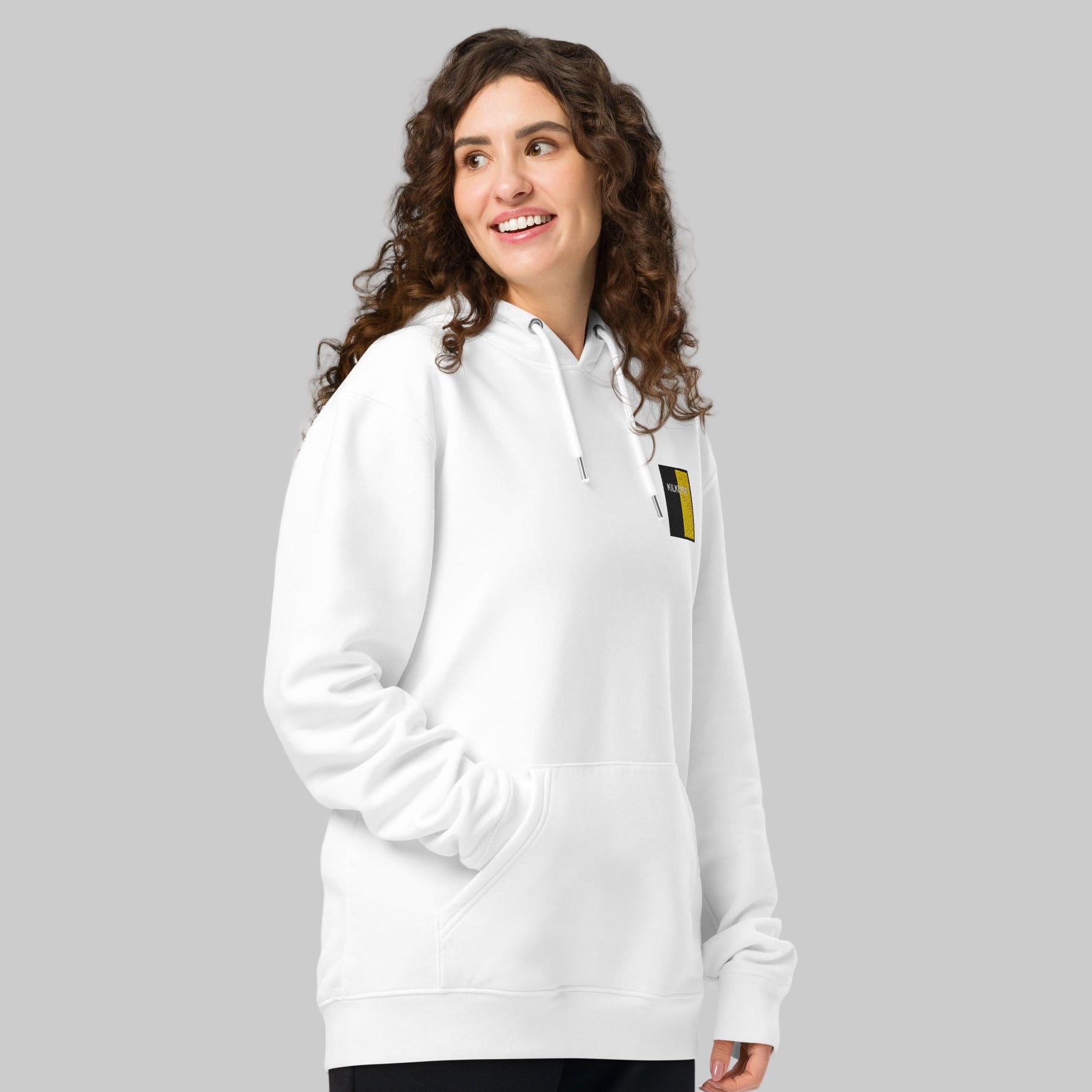 Woman wearing a white hoodie with Kilkenny emblem on a white background