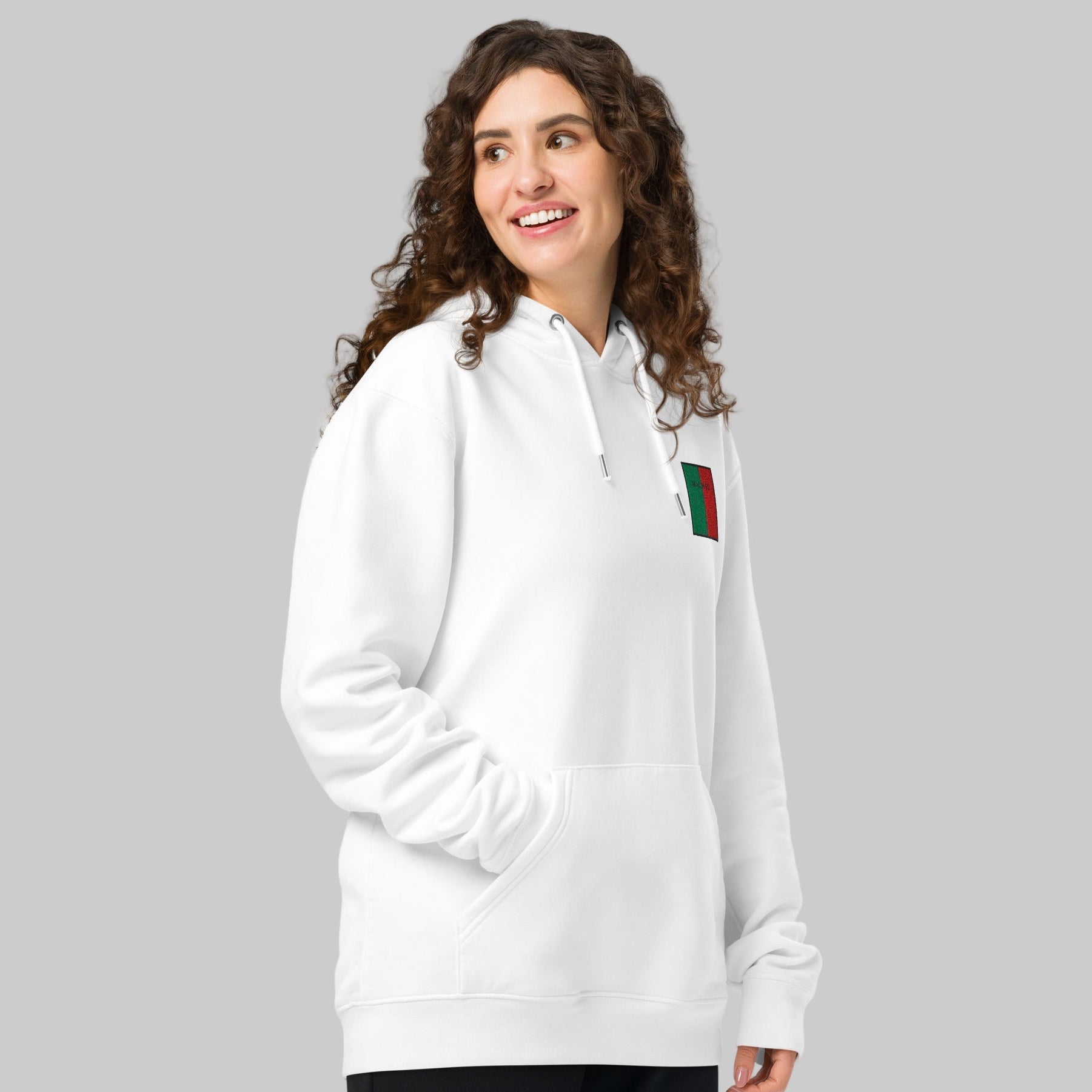Woman wearing a white hoodie with MAIGH Eo emblem